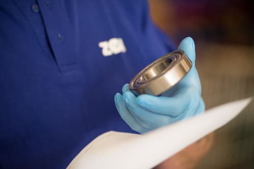 Un inspector comprueba a fondo un rodamiento durante el control de calidad